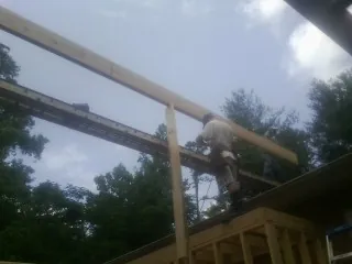 Carpenter setting a ridge beam over a new addition frame — Ice Dam Removal by Roofing Brothers in Pawnee
