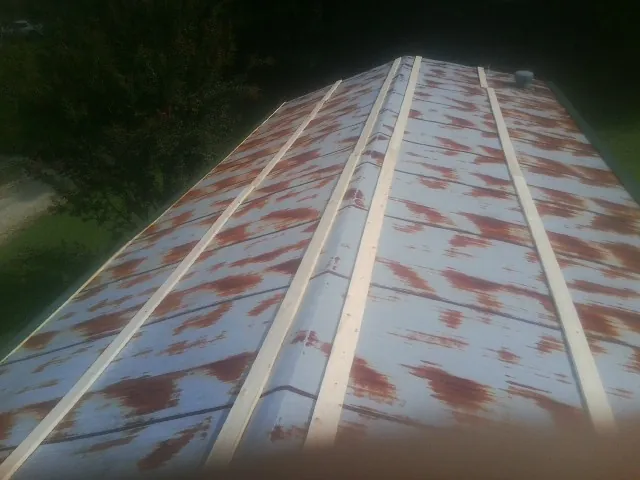 Rusted metal roof panels with new wood purlins before replacement — Storm Damage Roof Repair in Pawnee by Roofing Brothers